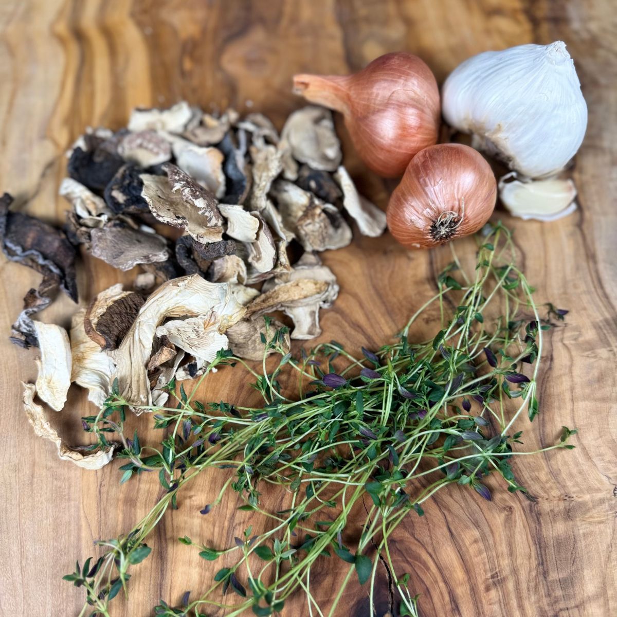 Dried mushrooms and herbs on cutting board