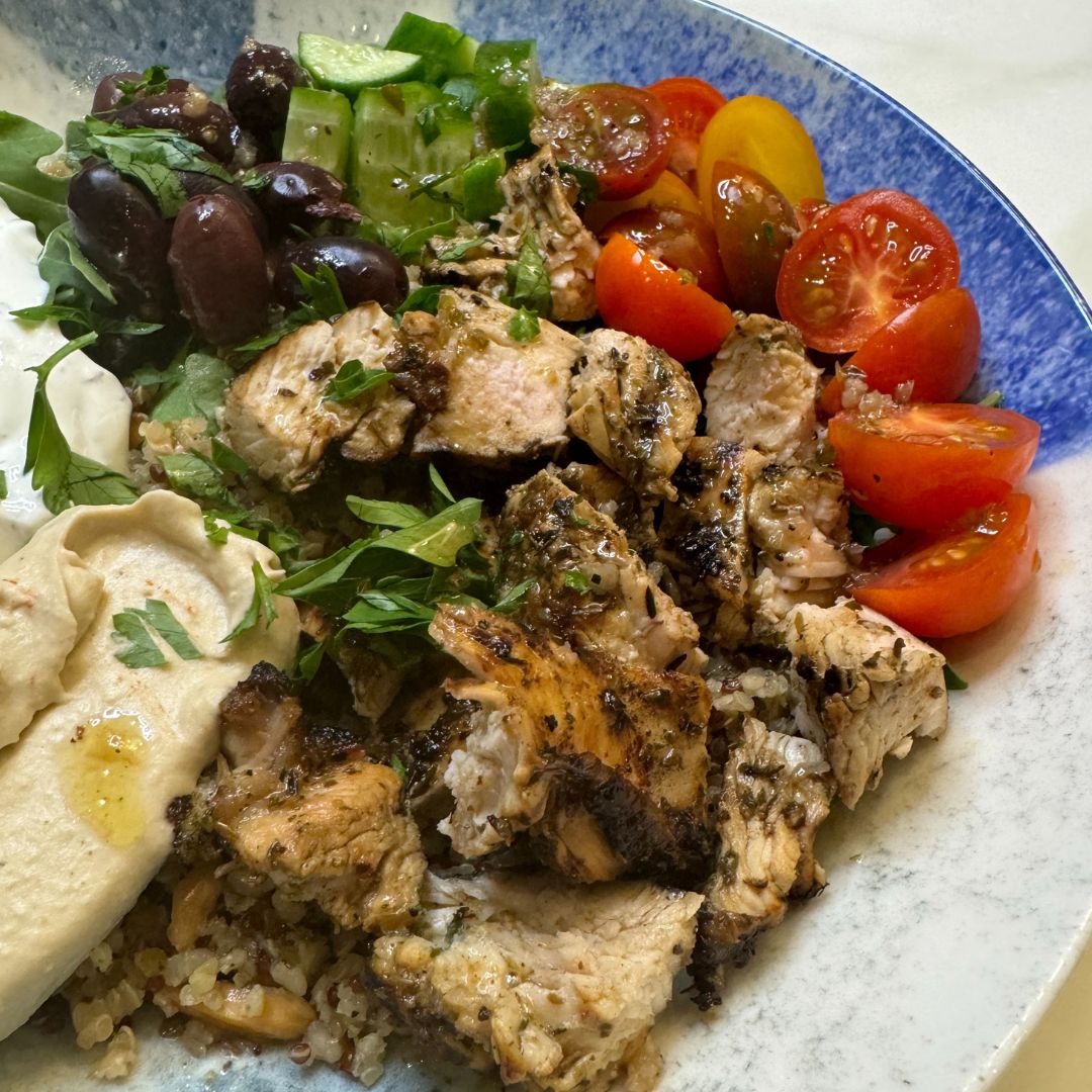 Grilled chicken in Greek bowl with greens and grains