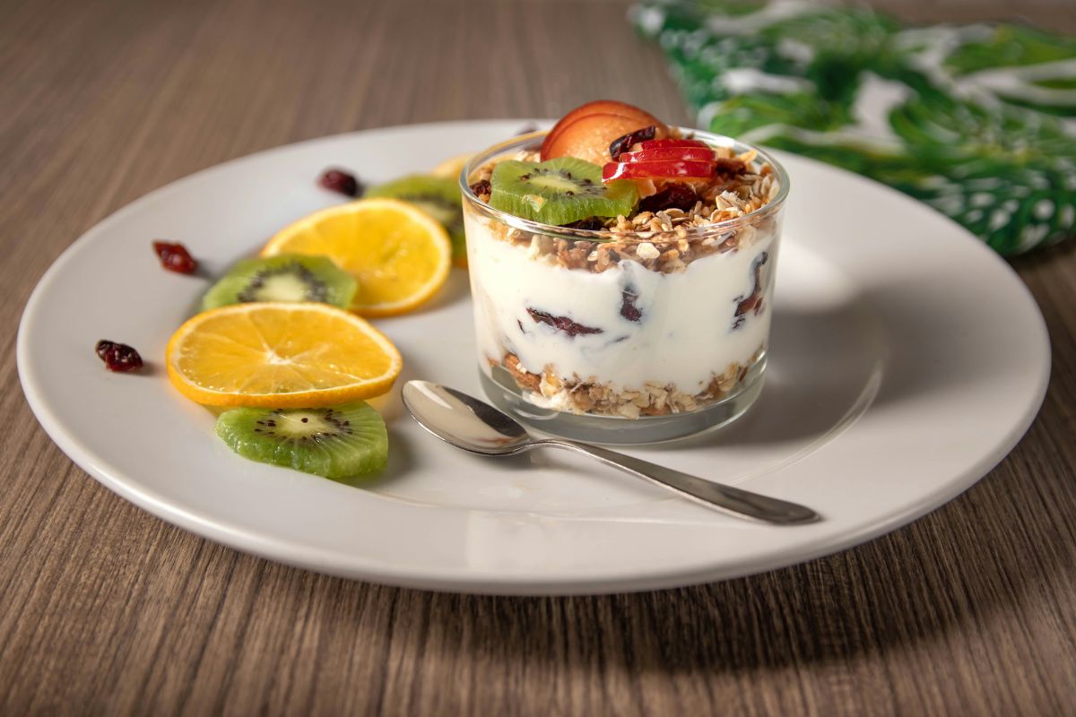 Yogurt with fruit in a cup served on a plate