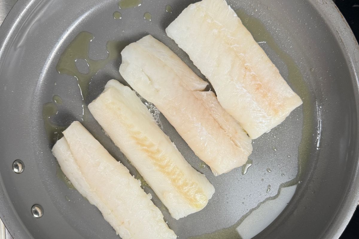 White fish fillets in skillet